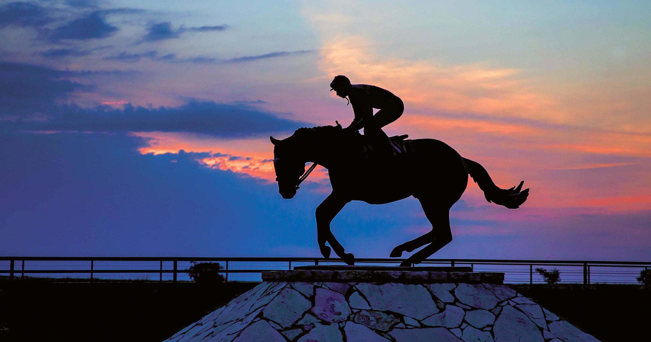 Four Sixes Ranch heritage sculpture depicting a horse and rider silhouetted at sunset, symbolizing the legacy, pedigree, horsemanship, and ranching traditions that define the historic 6666 Ranch in Texas.