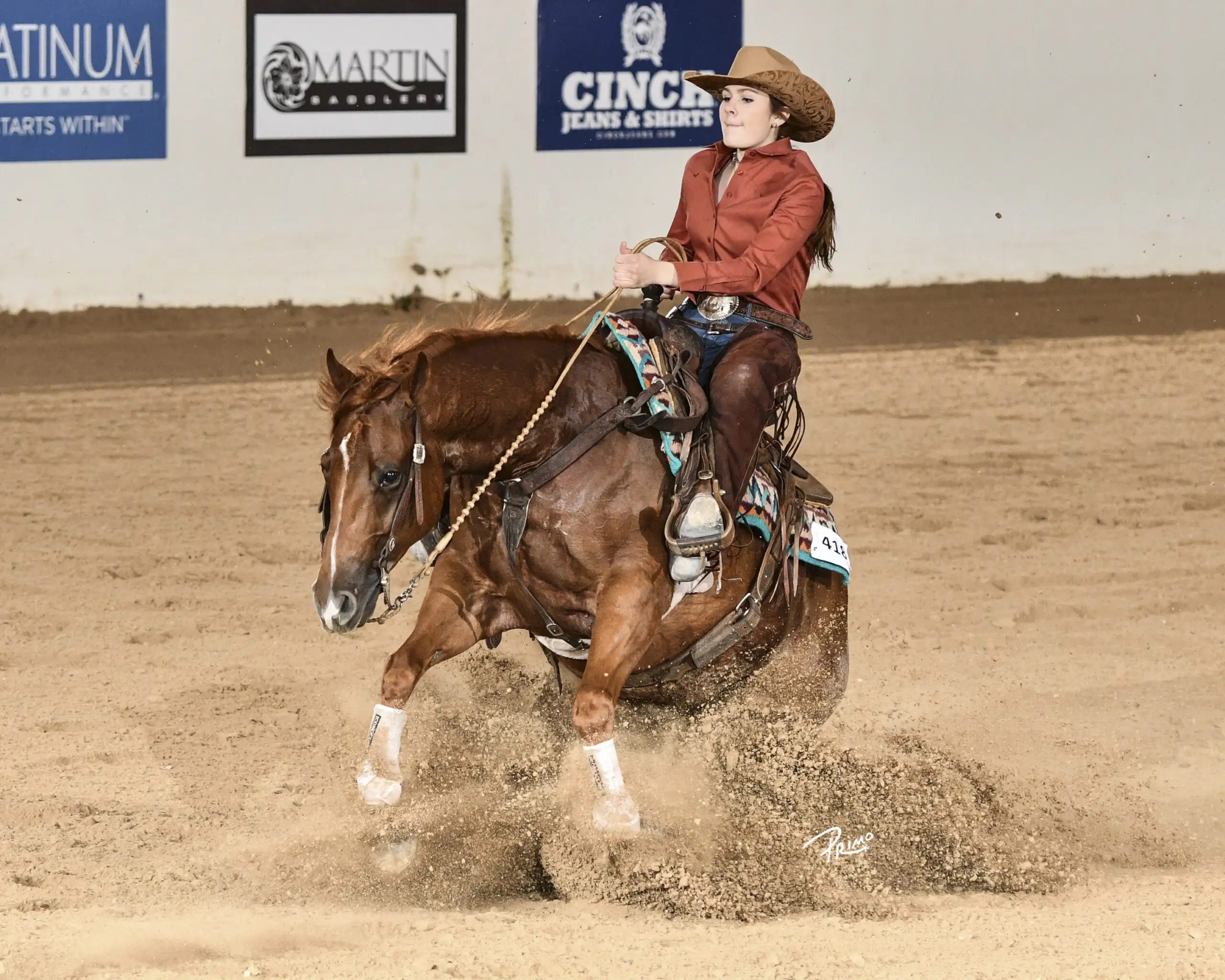 Playin Motown performs a sliding stop with a youth rider during a reining competition.